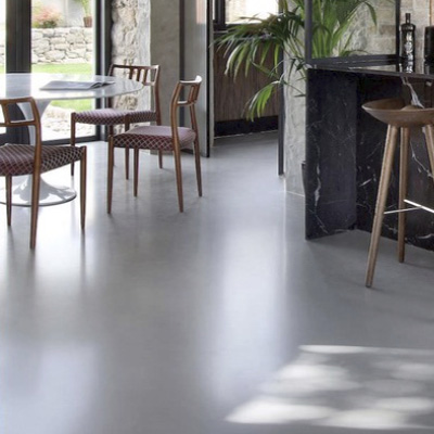 Sol en béton coulé gris clair dans une salle à manger moderne – réalisation Cojeni à Salon-de-Provence

