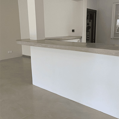 Plan de travail et sol en béton ciré clair dans une cuisine moderne – projet Cojeni à Salon-de-Provence