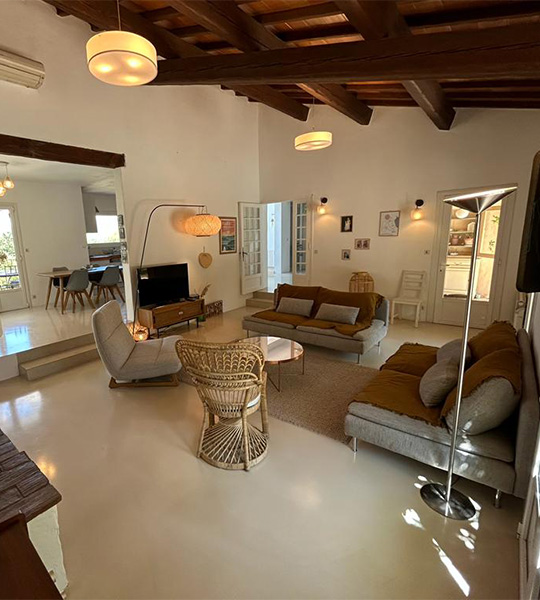 Grand salon avec sol en béton ciré beige et plafond en bois – projet Cojeni à Salon-de-Provence</p>
<p>