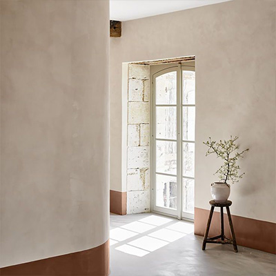 Mur en peinture à la chaux avec soubassement brun dans une pièce lumineuse – projet Cojeni à Salon-de-Provence